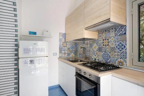 a small kitchen with a stove and a refrigerator at Blue & Green Apartments in Erchie