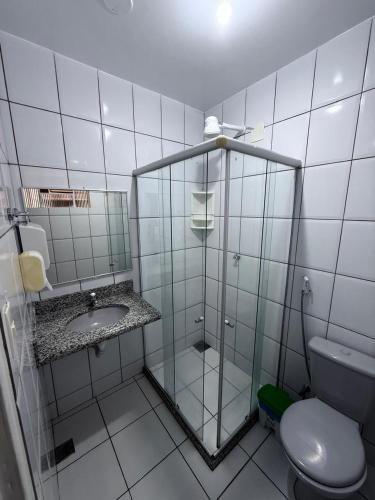 a bathroom with a glass shower and a toilet at Modenesi Hotel in Linhares