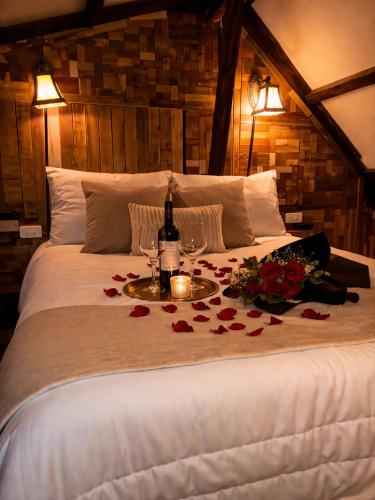 a bed with a table with flowers and wine glasses at Cabaña en la Calera BersaNina in La Calera