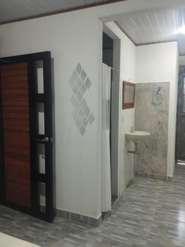a bathroom with a shower and a sink and a door at CASA HOTEL EL PRADo in Mesetas