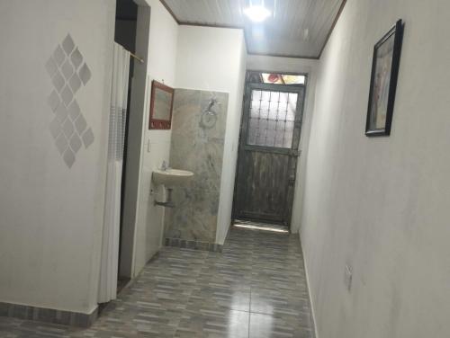 a hallway with a bathroom with a sink and a door at CASA HOTEL EL PRADo in Mesetas