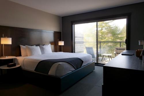 a bedroom with a large bed and a balcony at Tofino Resort + Marina in Tofino