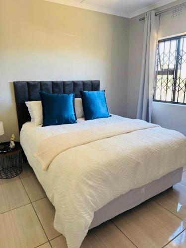 a large bed with blue pillows in a bedroom at 3 on Eland in Vryheid
