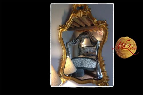 a picture of a mirror with a bed in it at Manoir de Livet in Saint-Germain-de-Livet