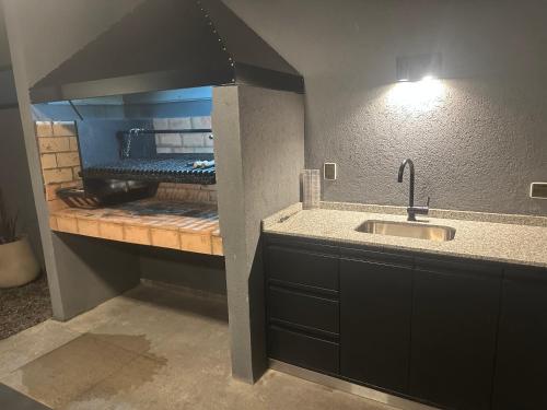 a kitchen with a sink and a kitchen with a stove at Petit BANFIELD in Banfield