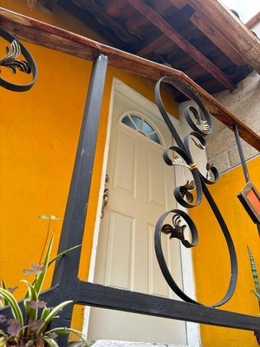 a front door of a yellow house with a white door at CHIK Coatepec Comfort in Coatepec