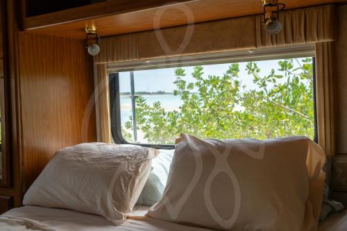 a bedroom with a window and a bed with white pillows at MUUN experience in Ciudad del Carmen