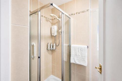 a bathroom with a shower with a glass door at Coastal Nest - Cosy flat in Irvine town centre - 5 minute drive from beach in Irvine