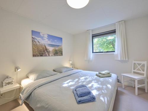 a bedroom with a bed with two towels on it at Chalet Sea Birds in Goedereede