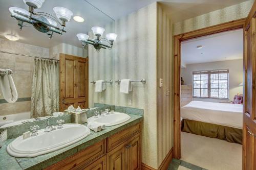 a bathroom with a sink and a bed in a room at Beaver Creek Village by Vail Resorts in Avon