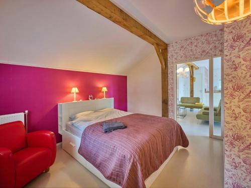 a bedroom with a bed and a red chair at Twente Village in Haaksbergen