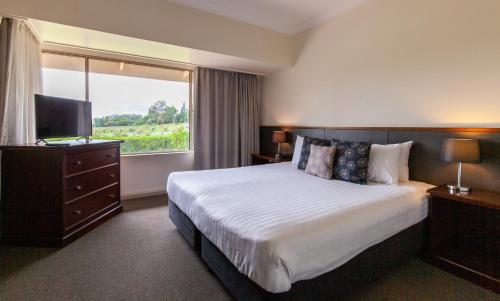 a hotel room with a large bed and a window at Harrigan's Hunter Valley in Pokolbin