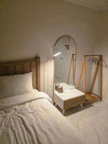 a bedroom with a bed and a table with a mirror at Stay GaeBong in Seoul