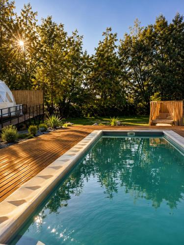 a swimming pool in a backyard with a wooden deck at Vilodge in Charrúa