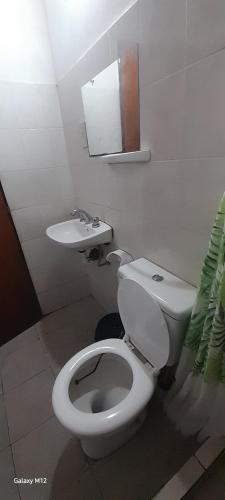 a white bathroom with a toilet and a sink at Cabañas Las Macluras in Colastiné