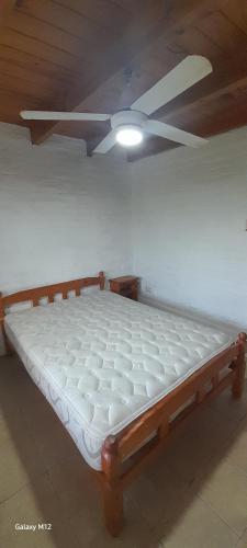 a bed in a room with a ceiling fan at Cabañas Las Macluras in Colastiné