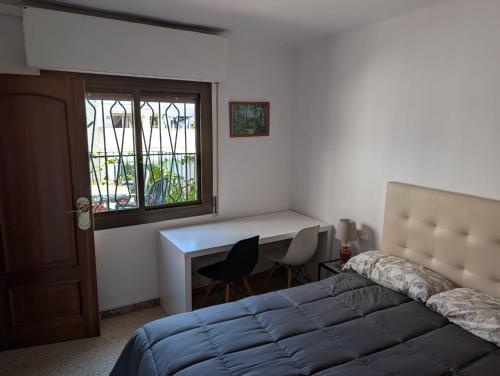 a bedroom with a bed and a desk and a window at Apartment near Fira Barcelona, Camp Nou, and the center of Barcelona in Hospitalet de Llobregat