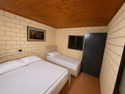 a small room with two beds and a window at Villa Adi in Ducaj