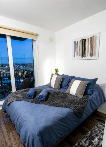 a bedroom with a large bed with blue pillows at Acogedor departamento céntrico vista al lago in Villarrica