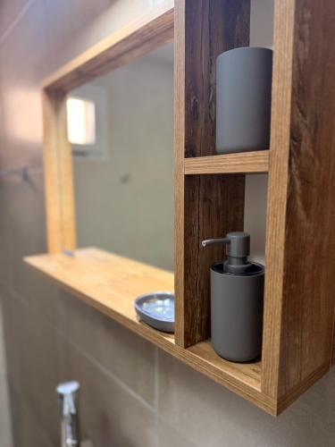 a wooden bathroom shelf with a sink and a mirror at Apart Zona Paula in San Juan