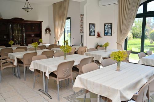 a room filled with tables and chairs with flowers on them at Adriatic Garden Rooms in Bregvija