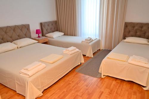 a room with two beds with towels on them at Adriatic Garden Rooms in Bregvija