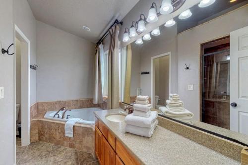 a bathroom with a tub and a sink and a mirror at Sunset Vista in Garden City
