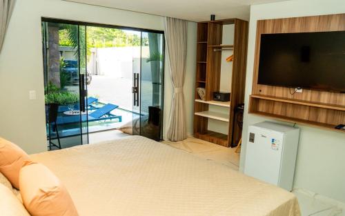 a bedroom with a bed and a flat screen tv at Pousada Caribdis in Paraipaba