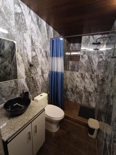 a bathroom with a toilet and a sink and a shower at Minkay-Lodge in Otavalo