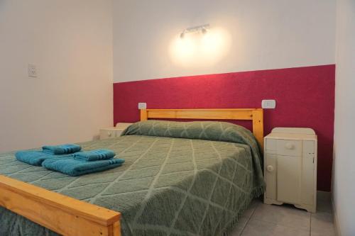 a bedroom with a bed with two blue pillows on it at "ATARDECER" Departamento a pocos minutos de termas in Chajarí