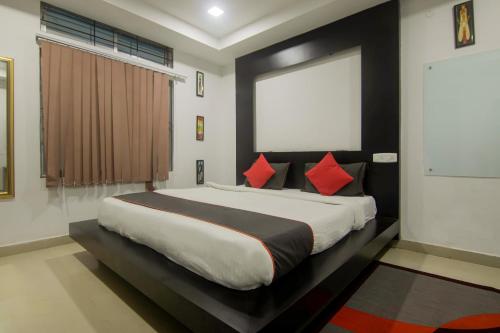 a bedroom with a large bed with red pillows at Hotel OThe Blu Bell in Guwahati