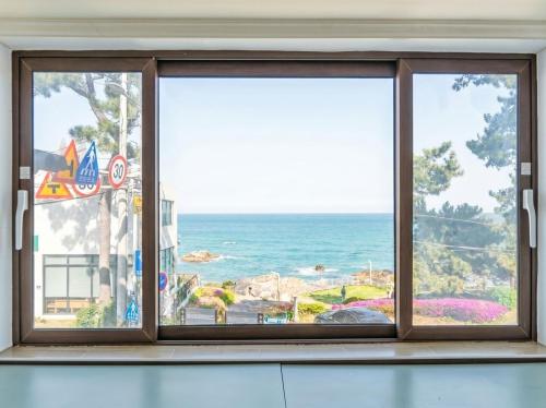 a window with a view of the ocean at Onseul Pension Busan in Busan