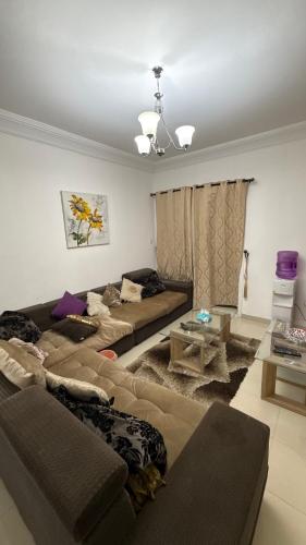 a living room with two couches and a table at Sharjah Room in Sharjah