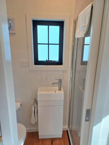 a small bathroom with a sink and a window at BIG4 Stratford Caravan Park in Stratford