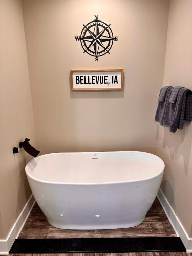 a white bath tub in a bathroom with a sign at Grand River Suite in Bellevue