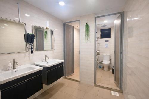 a bathroom with a sink and a shower and a toilet at K2 Guesthouse in Singapore