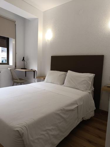 a bedroom with a large bed with white sheets at São Neutel in Chaves
