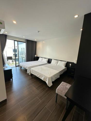 a bedroom with two beds and a large window at Villa Florent in Thanh Hóa