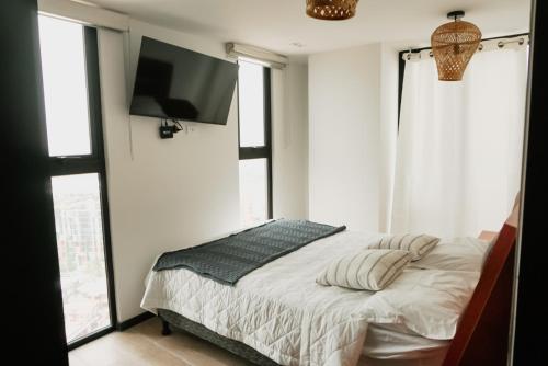 a bedroom with a bed and a flat screen tv at Luxury Skyline Apartment with pool, city views & volcano views in El Rodeo