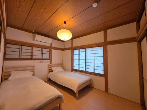a bedroom with two beds and a light fixture at GateFuji Fujisan Station in Fujiyoshida