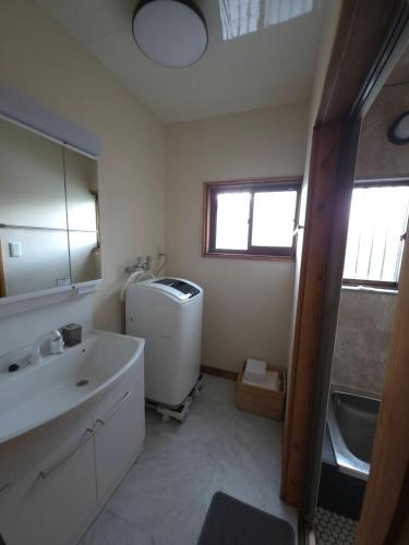 a bathroom with a sink and a washing machine at GateFuji Fujisan Station in Fujiyoshida
