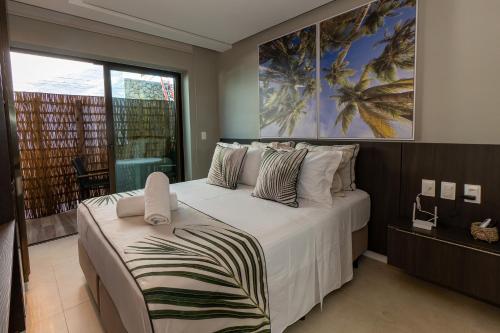 a bedroom with a large bed and a large window at Pousada de Charme Refugio da Villa - Pé na Areia in Porto De Galinhas