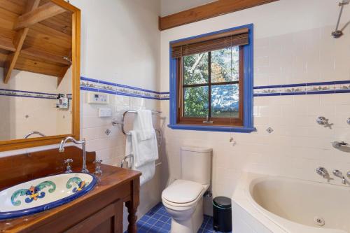 a bathroom with a tub and a toilet and a sink at Leura Lodge in Leura