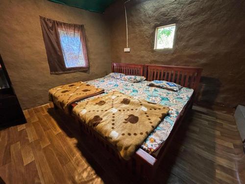a bedroom with a bed with a comforter on it at Amber Mount Resorts in Kanthalloor