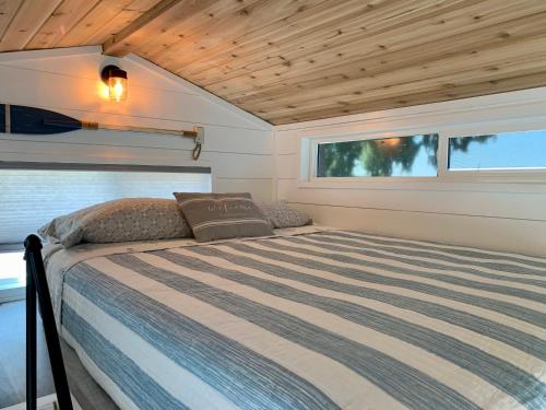a bed in a tiny house with a window at The Eagle’s View (Tiny Home 4) in Bellevue