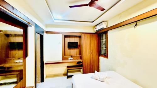 a room with a table and a ceiling fan at Half Moon Grand in Chennai