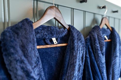 a row of blue coats hanging on a rack at Hotel Scandi Poulsbo in Poulsbo