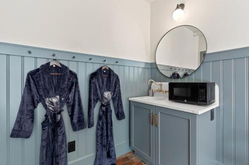 a bathroom with two robes on hangers and a mirror at Hotel Scandi Poulsbo in Poulsbo