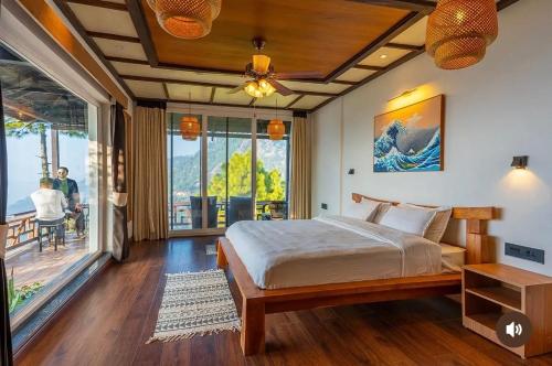 a bedroom with a bed and a balcony at The Wild Sakura in Mukteshwar
