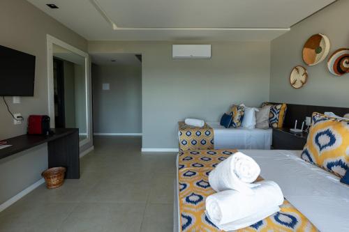 a room with a bed with towels on it at Pousada de Charme Refugio da Villa - Pé na Areia in Porto De Galinhas
